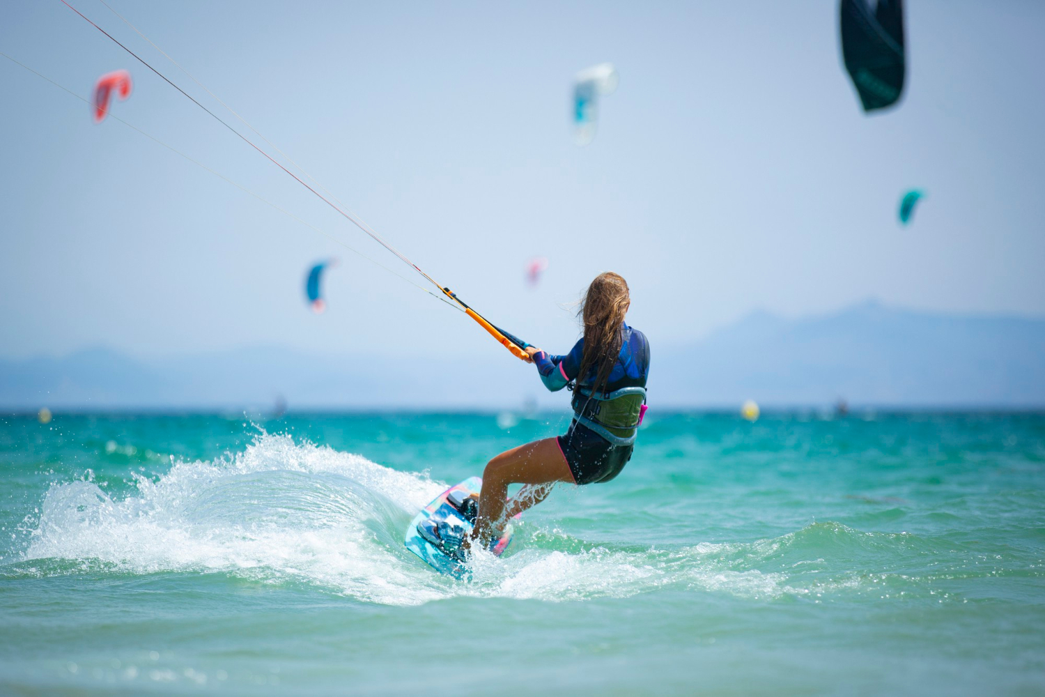 młoda kobieta oprawiająca kitesurfing